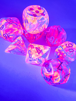 Picture of Black Light special polyhedral dice set, glowing under a black light.