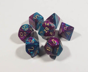 A close up of the Chessex Gemini Purple and Teal polyhedral dice set in its package.
