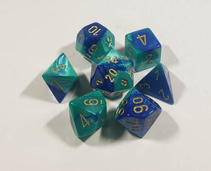 A close up of the Chessex Gemini Blue Teal polyhedral dice set.