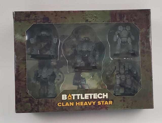 A packaged set of BattleTech Clan Heavy Star miniatures displaying various mechs in a display box.