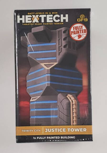 Packaged BattleTech Hextech Terrain piece featuring a 'Justice Tower' building model, pre-painted and ready for use in gaming.