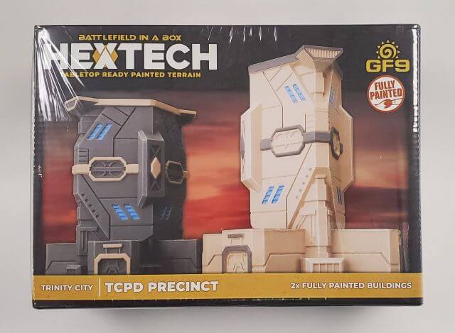 Packaging for BattleTech Hextech Terrain W01 TCPD Precinct, featuring two pre-painted 6mm terrain buildings ready for use in tabletop gaming.