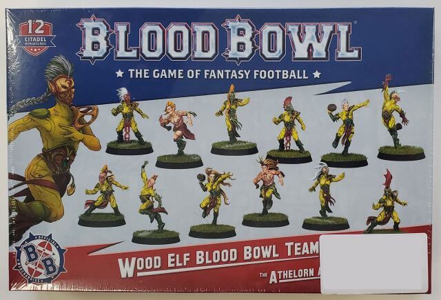 A box of Blood Bowl Wood Elf Team miniatures featuring various elf characters in different poses, with yellow and green clothing, along with the team's name and the number of pieces included.