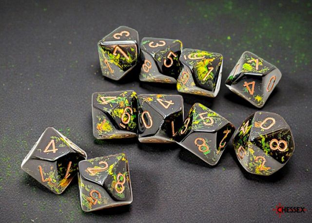 Set of polyhedral dice with green and gold numbering on a dark surface