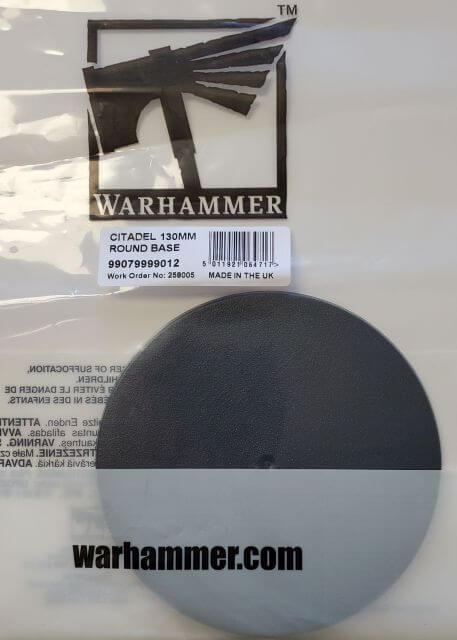 A packaged Citadel 130mm Round Base with the Warhammer brand visible on the packaging.