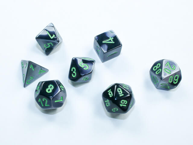 A close of the Chessex Gemini Black-Grey with green mini dice set.