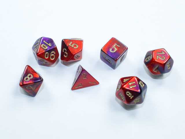 A close of the Chessex Gemini Purple-Red with gold mini dice set.