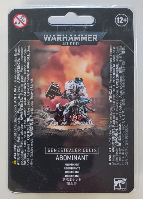Packaging for Genestealer Cults Abominant miniature, featuring an illustration of the Abominant on a 40mm round base with a Mindwyrm Familiar, against a backdrop of a battle scene.
