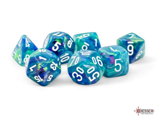 A set of seven multicolored polyhedral dice with numbers ranging from 0 to 9, predominantly blue and green, on a white background.