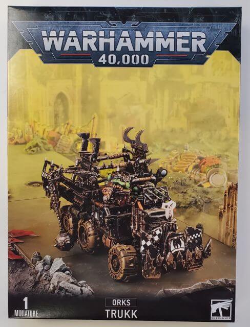 A Warhammer 40,000 Ork Trukk box set featuring a multi-part plastic model with various accessories such as a bolt-on big shoota, boarding plank, wrecker ball, and reinforced ram.