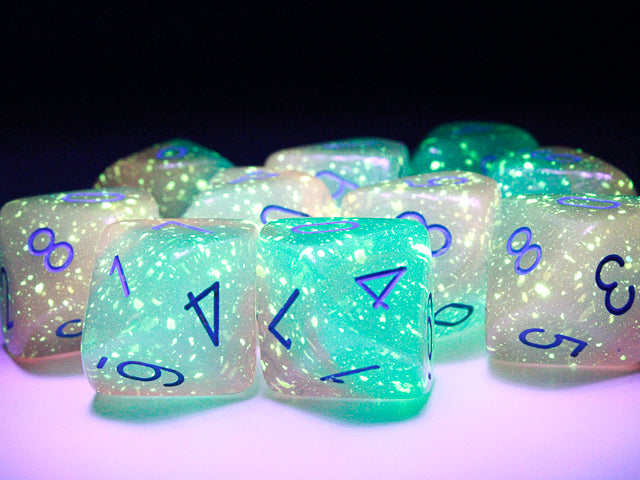 Examples of the Gemini Gel Green-Pink with blue d10 set under a blacklight to highlight their luminescent quality.