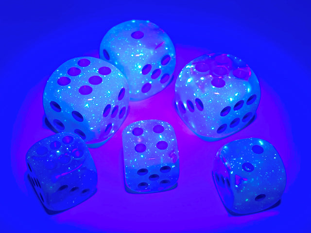 Examples of the Gemini Pearl Turquoise-White with blue 12mm dice sets under a blacklight to high light their luminescent features.