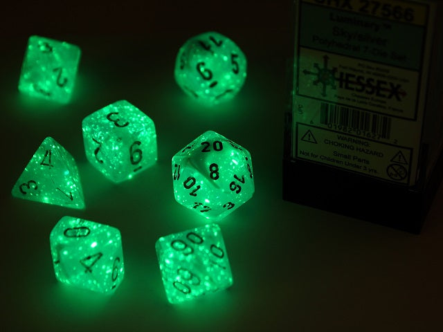 A close up of the Chessex Luminary Sky wth Silver polyhedral set under black light.