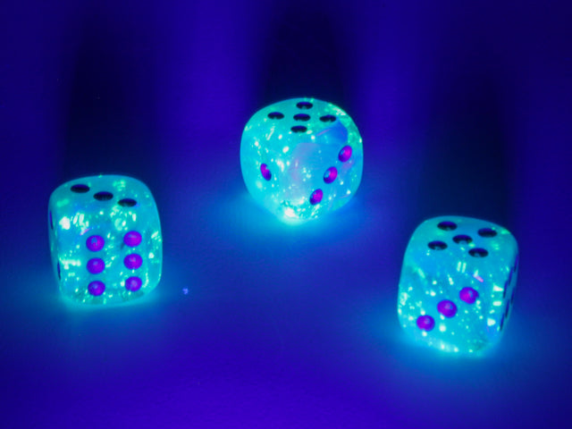 A close up of the Chessex Luminary Sky d6 under blacklight.