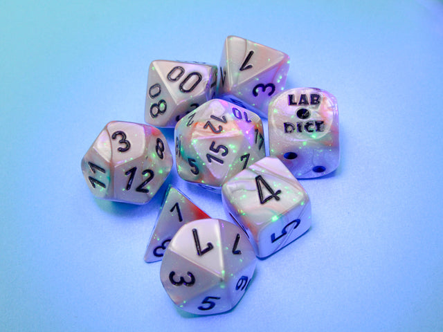 Lustrous Sea Shell polyhedral dice set glowing under a black light. 