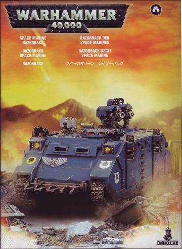 Product image of a Space Marines Razorback / Rhino scale model kit from the Warhammer 40,000 series, predominantly blue with battle damage effects in the background.