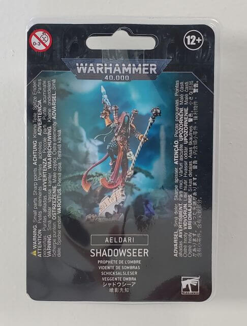Packaged model of Aeldari Shadowseer from Warhammer 40,000, showing the character with a shuriken pistol and the product information on the packaging.