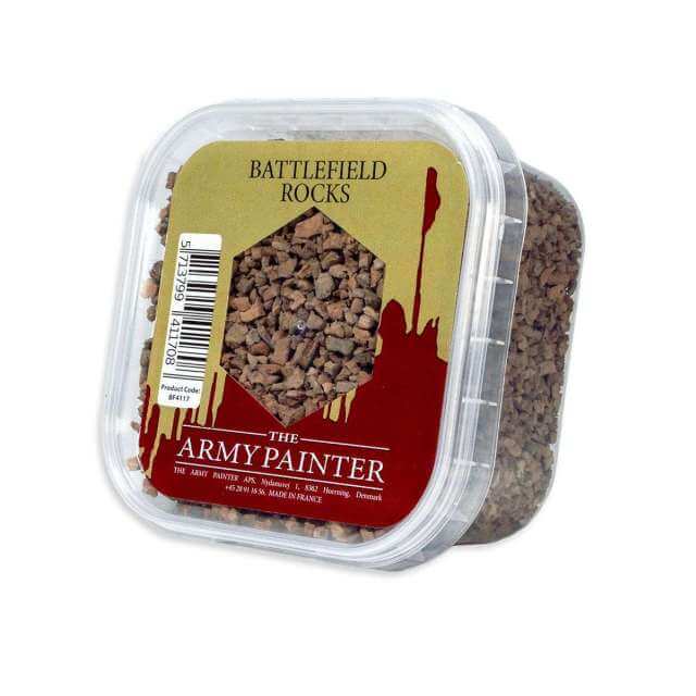 A clear plastic container labeled 'BATTLEFIELD ROCKS' by The Army Painter, filled with small, brown miniature bases representing realistic rocks for model bases.