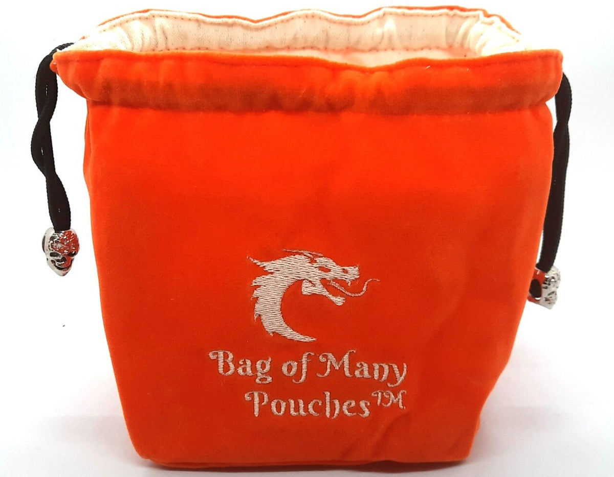 An orange dice bag with 'Bag of Many Pouches' embroidered on it, featuring a skull toggle on the drawstring.