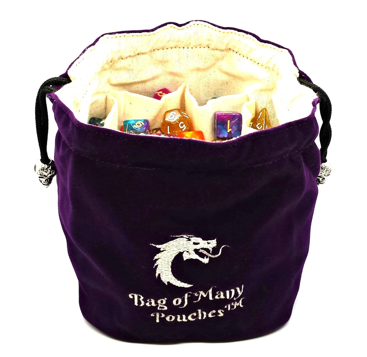 A purple dice bag with silver skull toggles and white drawstrings, embroidered with a dragon head logo and the text 'Bag of Many Pouches'.
