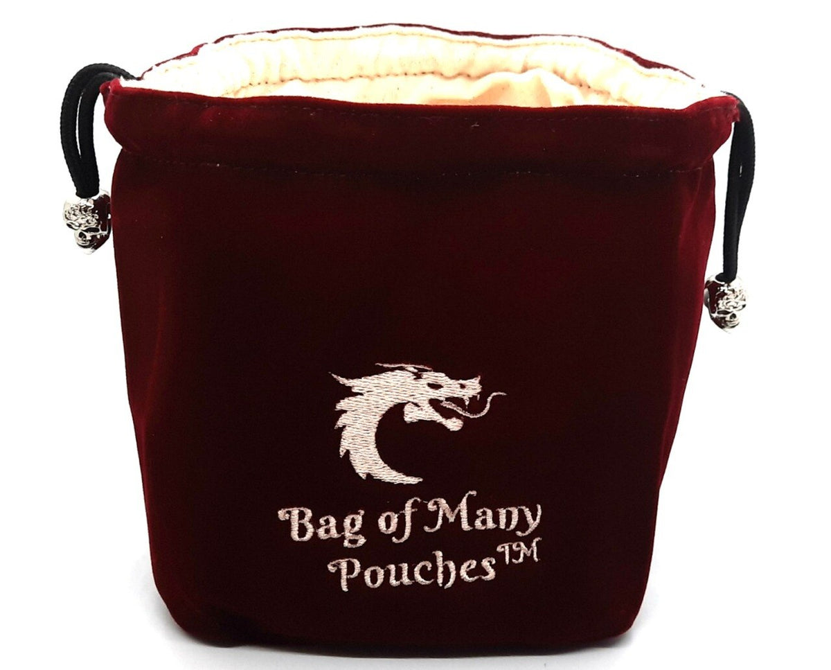A red dice bag with 'Bag of Many Pouches' embroidered on it, featuring a silver skull toggle and multiple compartments.
