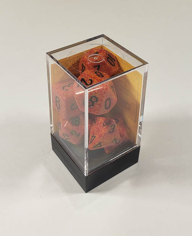 A close up of the Chessex specked Fire polyhedral dice set in its package.