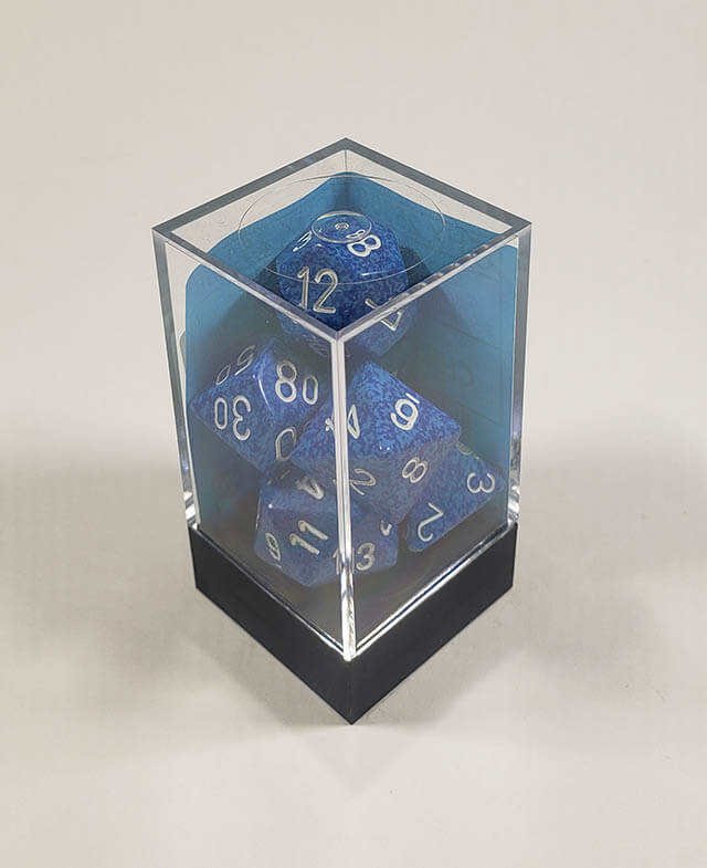 A close up of the Chessex specked Water polyhedral dice set in its package.