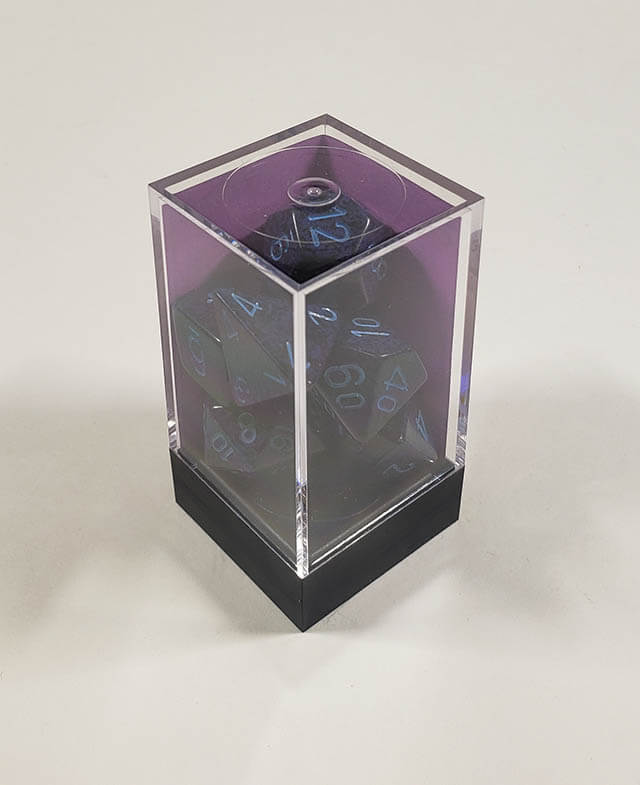 A close up of the Chessex specked Cobalt polyhedral dice set in its package.