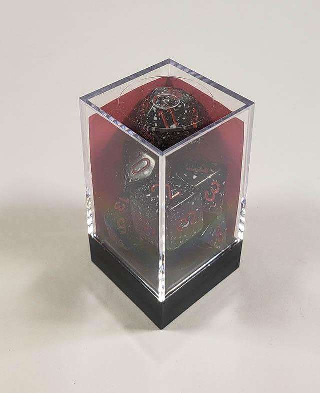 A close up of the Chessex specked Space polyhedral dice set in its package.