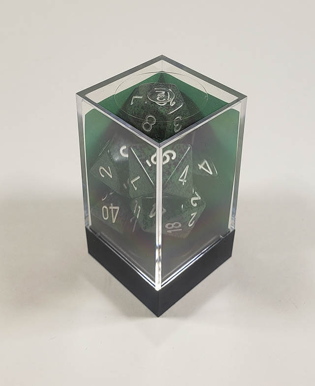 A close up of the Chessex specked Recon polyhedral dice set in its package.