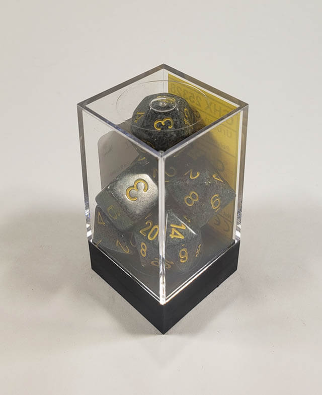 A close up of the Chessex specked Urban Camo polyhedral dice set in its package.