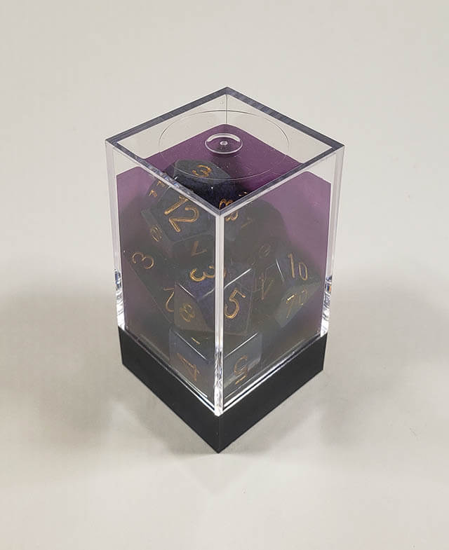 A close up of the Chessex specked Golden Cobalt polyhedral dice set in its package.