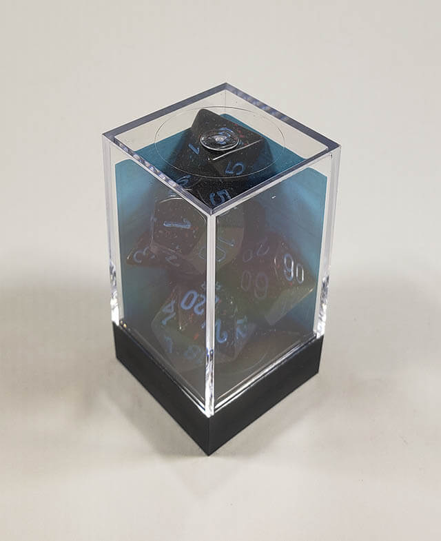 A close up of the Chessex specked Blue Stars polyhedral dice set in its package.