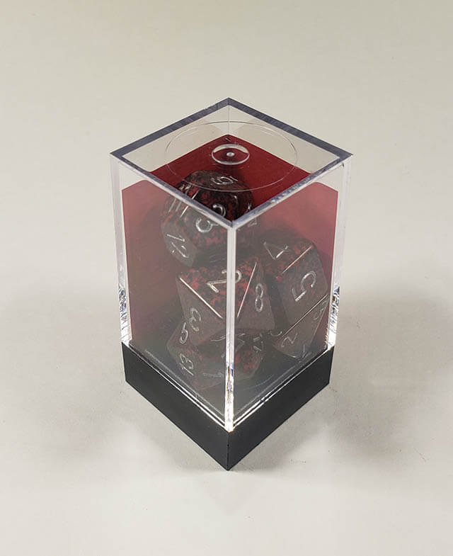 A close up of the Chessex specked Volcano polyhedral dice set in its package.