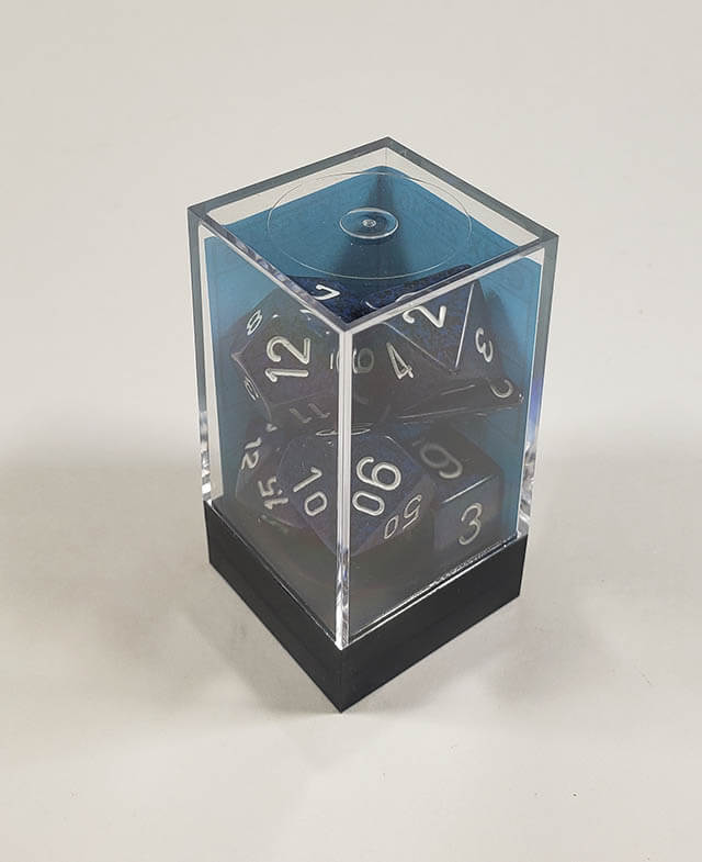 A close up of the Chessex specked Stealth polyhedral dice set in its package.