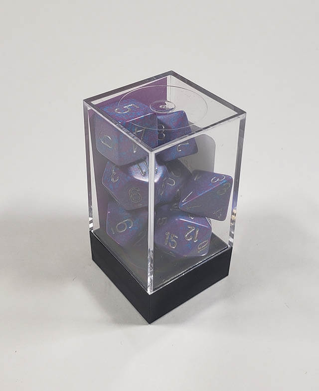 A close up of the Chessex specked Silver Tetra polyhedral dice set in its package.