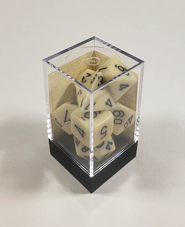 A close up of the Chessex Opaque Ivory with black polyhedral dice set in its package.