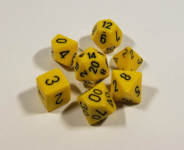 A close up of the Chessex Opaque Yellow with black polyhedral dice set.