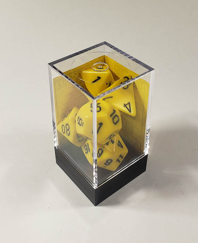 A close up of the Chessex Opaque Yellow with black polyhedral dice set in its package.