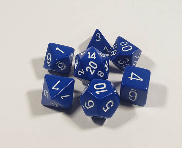 A close up of the Chessex Opaque Blue with White polyhedral dice set in its package.