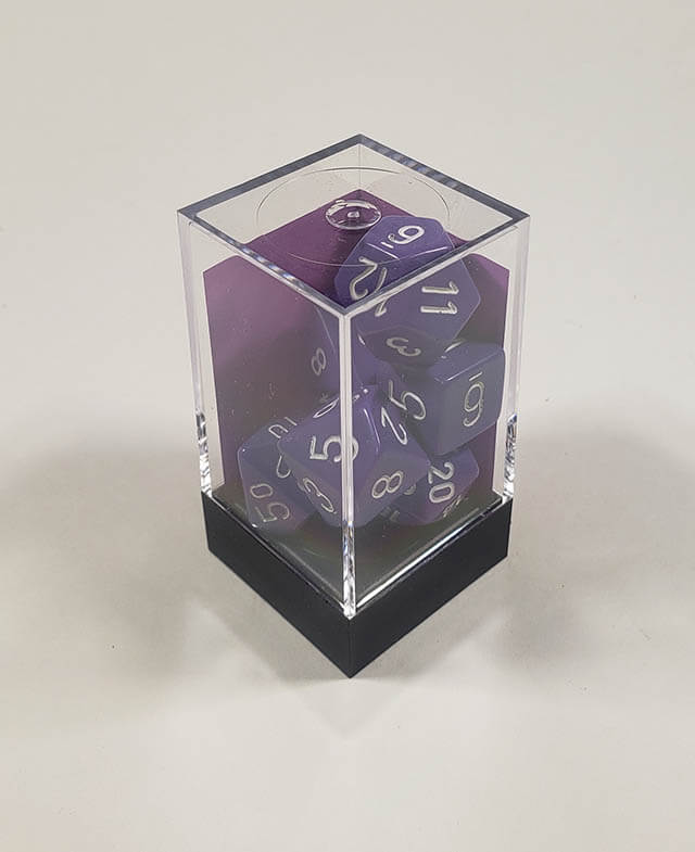 A close up of the Chessex Opaque Purple with White polyhedral dice set in its package.