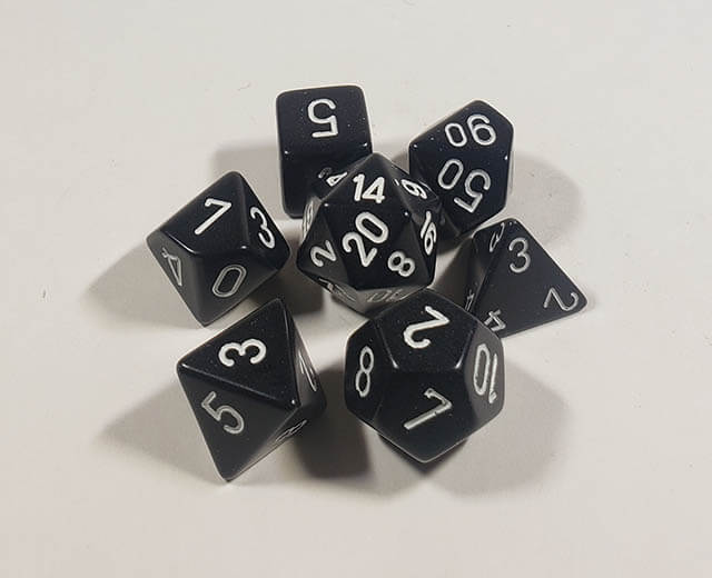 A close up of the Chessex Opaque Black with White polyhedral dice set.