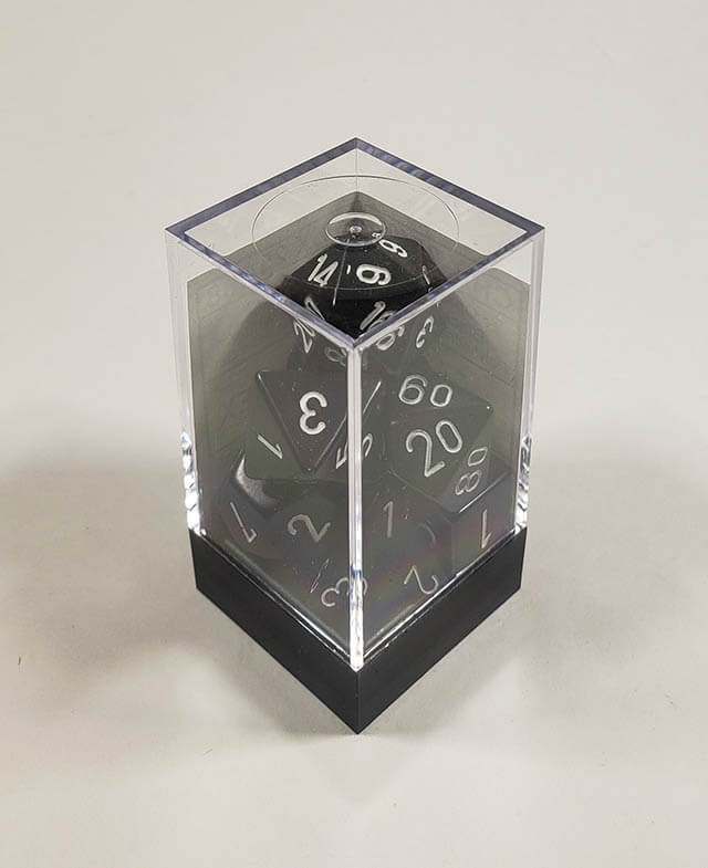 A close up of the Chessex Opaque Black with White polyhedral dice set in its package.