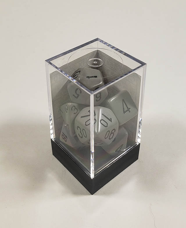 A close up of the Chessex Opaque Grey with black polyhedral dice set in its package.