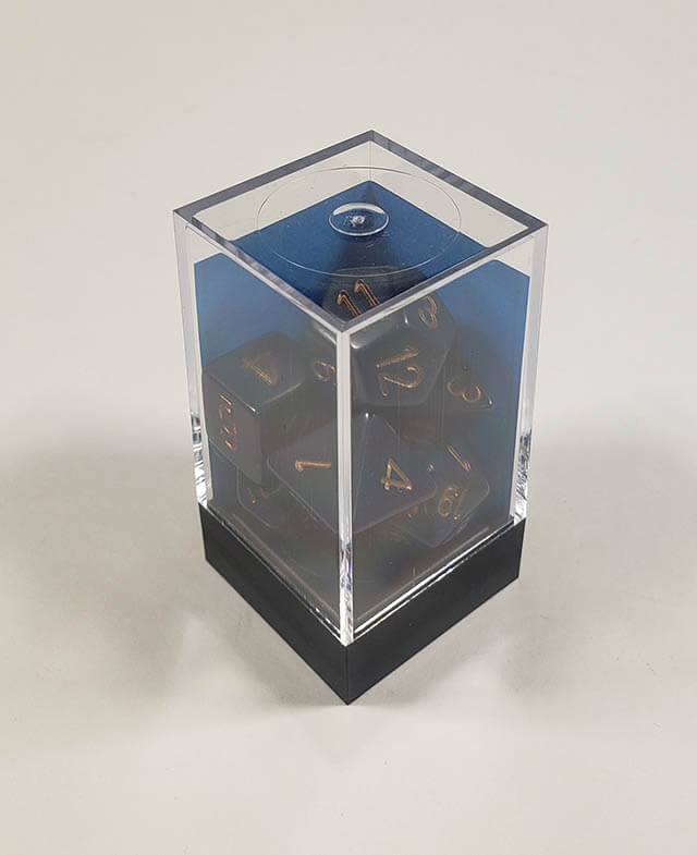 A close up of the Chessex Opaque Dusty Blue with copper polyhedral dice set in its package.