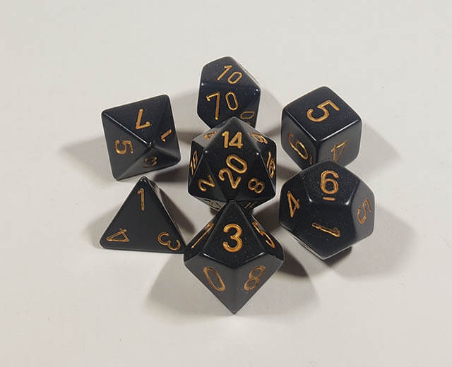 A close up of the Chessex Opaque Black with gold polyhedral dice set.