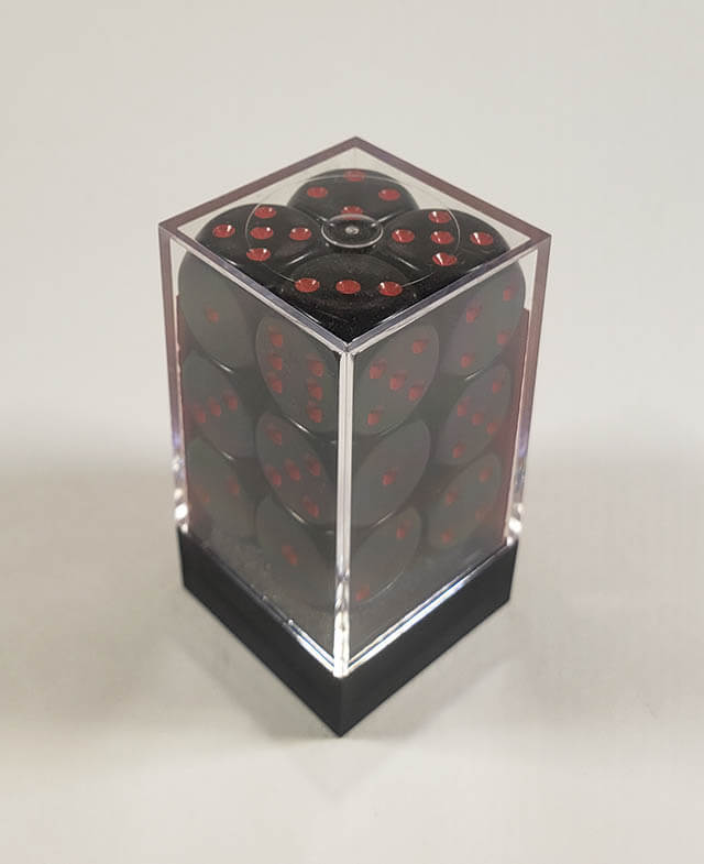 A close up of the Chessex Opaque Black with Red 16mm d6 dice set in its package.