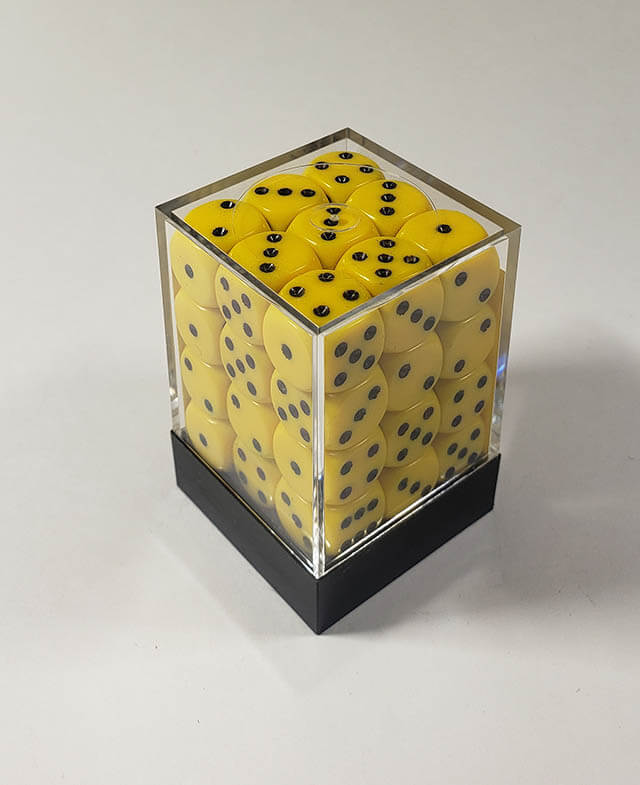 A close up of the Chessex Opaque  Yellow with Black 12mm d6 dice set in its package.