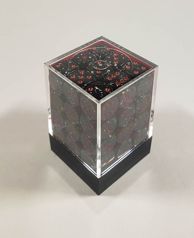 A close up of the Chessex specked space 12mm d6 dice set in its package.