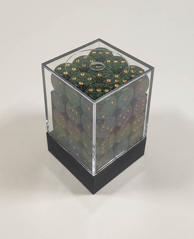 A close up of the Chessex specked golden recon 12mm d6 dice set in its package.